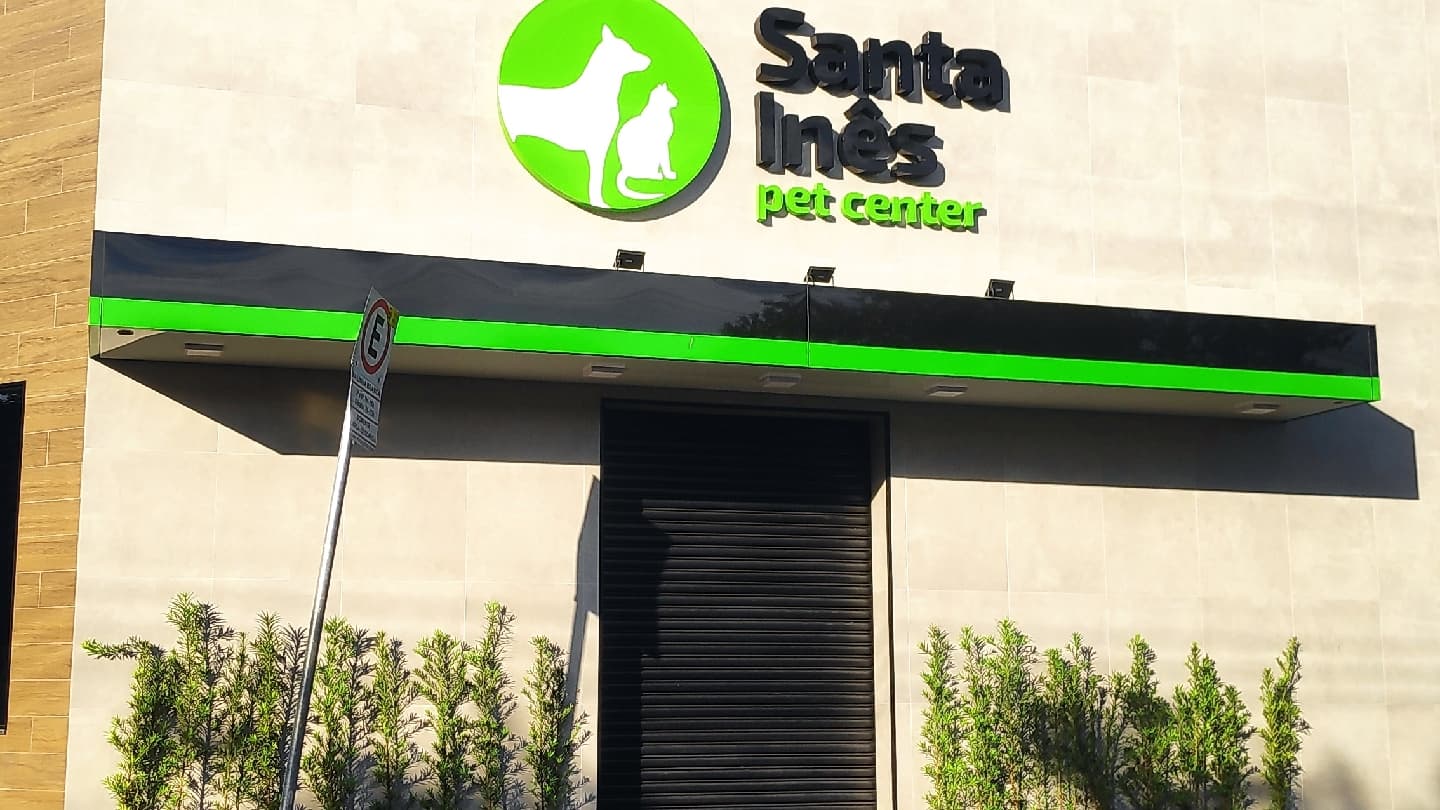 Letreiro da Santa Inês pet center em relevo na fachada, com o toldo preto e a faixa verde embaixo